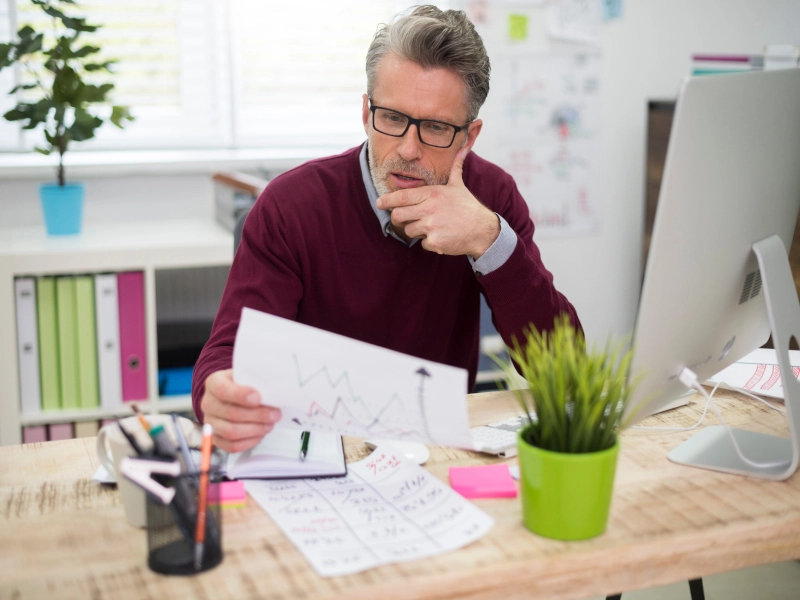 Homem analisando um grafico, com os resultados da empresa em um periodo